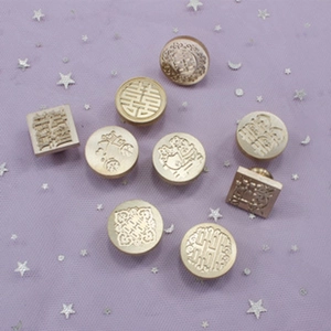 Detailed close-up of golden brass wax seal heads with traditional double joy patterns