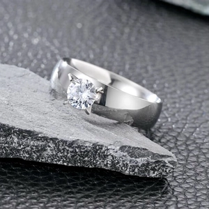 Macro view of a silver stainless steel ring with a round-cut zircon in a four-prong setting
