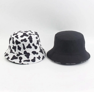 Detail shot of the black and white cow print and solid black cotton bucket hat texture