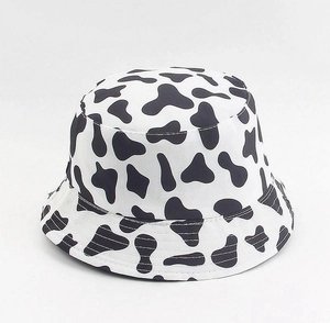 Detail of a black and white cow print bucket hat with a wide brim and soft cotton texture