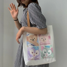 Vue détaillée d'un sac fourre-tout en toile blanche avec imprimé dessin animé et bandoulière