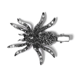 Detail of a spider-shaped metal hair clip encrusted with sparkling rhinestones and duckbill grip