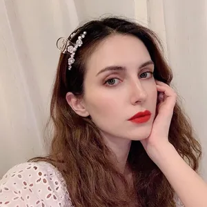 Elegant circular hair claw with white crystals and pearl flowers on female model