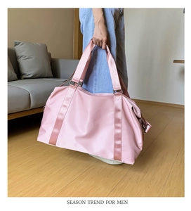 Detailed view of pink waterproof fitness bag with reinforced woven handles and metal hooks