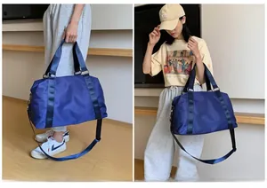Detail of navy blue waterproof fitness bag showing detachable strap and hand-carry handles