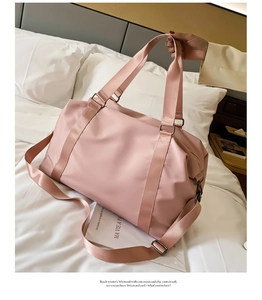 Pink waterproof nylon gym bag with reinforced handles and adjustable strap on white bedding