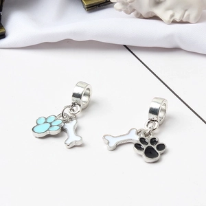 Detail of DIY metal charms featuring enamel dog paw and bone designs for keychains