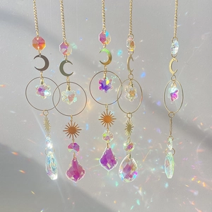 Crystal suncatcher set with gold moon and sun charms creating vibrant rainbow light