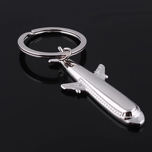 Macro detail of silver metal fighter jet keychain with smooth reflective finish