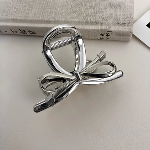 Detailed view of a silver butterfly-shaped metal hair claw clip with a glossy finish