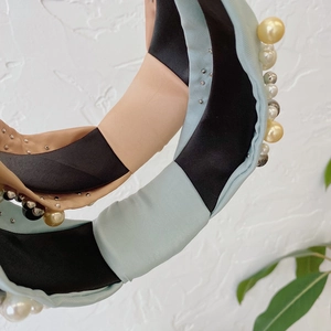 Close-up of tricolor fabric headband with faux pearls and sparkling metallic rhinestones