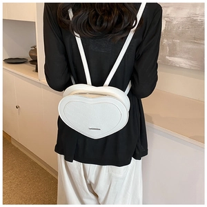 Chic white heart-shaped PU leather backpack with embossed patterns on model