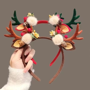 Plush Christmas reindeer antler headband with festive pine cones and berries for holiday decor