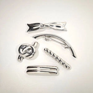 Detail of 5-piece silver metal hair clip set featuring bow and twist knot designs