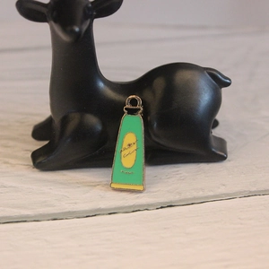 Macro view of a green and yellow enamel watercolor tube pendant on a black deer stand