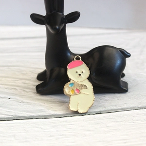 Macro shot of cute white animal alloy pendant with pink beret and colorful palette