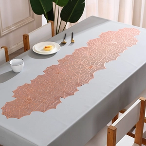 Detailed view of rose gold spiderweb lace table runner with intricate hollow-out texture