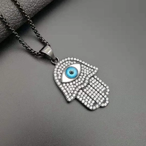 Black Hamsa Hand necklace with blue Evil Eye and clear crystals on a box chain