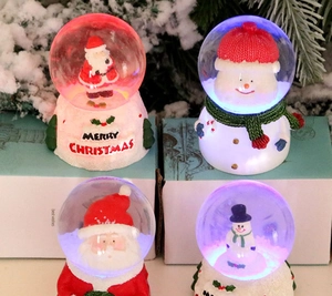 Luminous Christmas crystal balls with Santa and Snowman figures on white LED bases