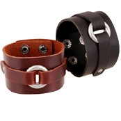Detalle de pulseras punk de cuero vintage en negro y marrón con anillos de metal plateado