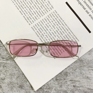 Macro detail of silver metal sunglasses with pink lenses and adjustable nose pads