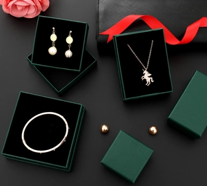 Deep green jewelry box detail showing velvet interior with pearl earrings and necklace