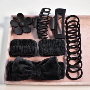 Flat lay of a 14-piece black hair accessory set with matte clips and plush bow headband