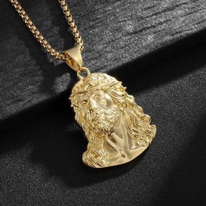 Macro shot of 18k gold plated Jesus head pendant with detailed crown of thorns on box chain