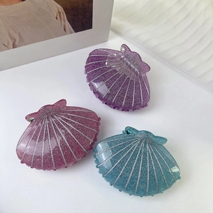 Three glitter shell hair claws in purple, pink and blue with rhinestone accents