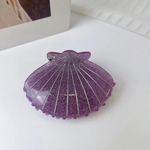 Detail of purple shell hair claw clip with silver glitter stripes and sparkling rhinestones