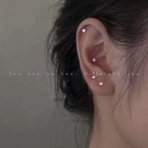 Close-up of silver stud earrings with micro-inlaid zircon on the model's ear lobe