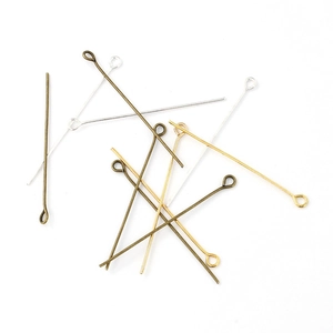 Macro shot of silver, gold, and bronze metal eye pins for DIY jewelry making
