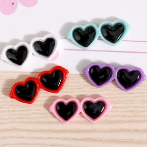 Detailed view of colorful mini heart-shaped sunglasses for DIY crafts and doll decoration