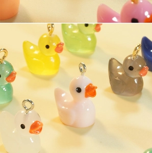 Macro shot of colorful resin duck charms with metal hooks for DIY jewelry crafts