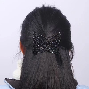 Detail of a black beaded elastic magic hair comb styling a messy bun on a female model