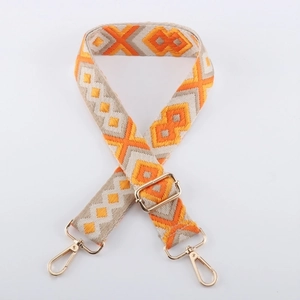 Detailed view of the orange and beige geometric woven strap with golden metal lobster clasps