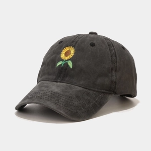 Close-up of yellow sunflower embroidery on dark grey washed cotton baseball cap texture