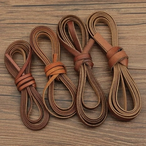 Flat leather cords in brown tones for DIY jewelry making on vintage wood background