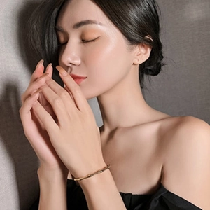 Fashionable gold bamboo style cuff bracelet shown on female model wrist for elegant styling
