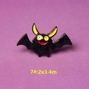 Macro detail of cartoon bat resin accessory with black body and large yellow eyes