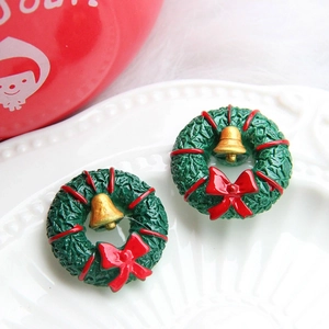 Close-up of Christmas wreath donut charm with golden bell and red bow decoration