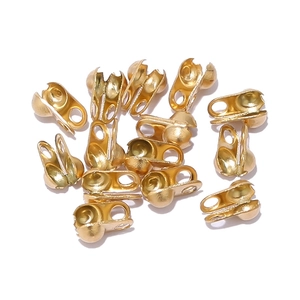 Macro shot of small golden stainless steel bead tips for jewelry making and DIY projects