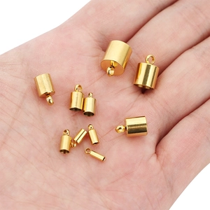 Golden stainless steel cylindrical cord ends and necklace clasps held in hand