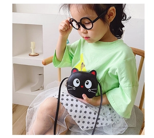 Detail of a cute black cat crossbody bag with ear accents on a young girl model