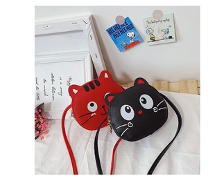 Detail view of mini PU leather cat shoulder bags in red and black colors for girls