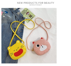 Detail of pink and yellow cat-shaped crossbody bags with gold metal zippers and leather texture