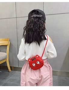 Rear view of a girl wearing a red leather cat-shaped mini crossbody bag with ears