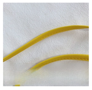 Detail of yellow leather shoulder strap with fine stitching for girls mini handbag