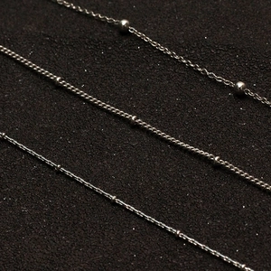 Three minimalist silver stainless steel necklace chains in bead and cross-link styles
