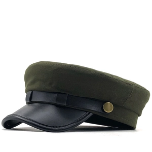 Detail of dark green wool military cap with black leather brim and golden side buttons